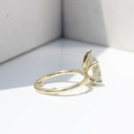 Hidden Halo Ring with pear-cut centre diamond, sleek cat claws, and delicate melee diamond halo set in luxurious recycled gold or platinum,