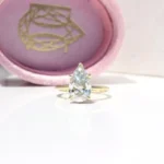 Hidden Halo Ring with pear-cut centre diamond, sleek cat claws, and delicate melee diamond halo set in luxurious recycled gold or platinum,