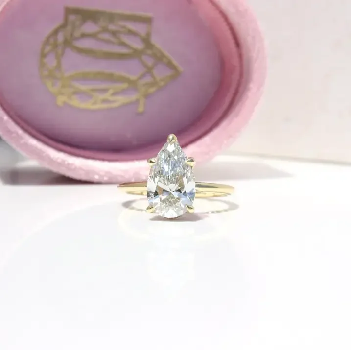 Hidden Halo Ring with pear-cut centre diamond, sleek cat claws, and delicate melee diamond halo set in luxurious recycled gold or platinum,