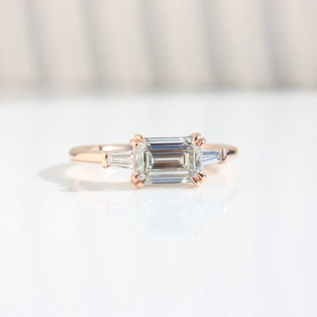 East West Trilogy Ring, Emerald & Tapered Baguette-Cut, trilogy ring, three stone ring, engagement ring, emerald cut diamond, laboratory-grown diamond, rose gold ring, recycled gold, danielle camera jewellery