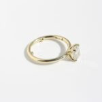 Yellow gold engagement ring with cushion cut diamond solitaire on minimalist band