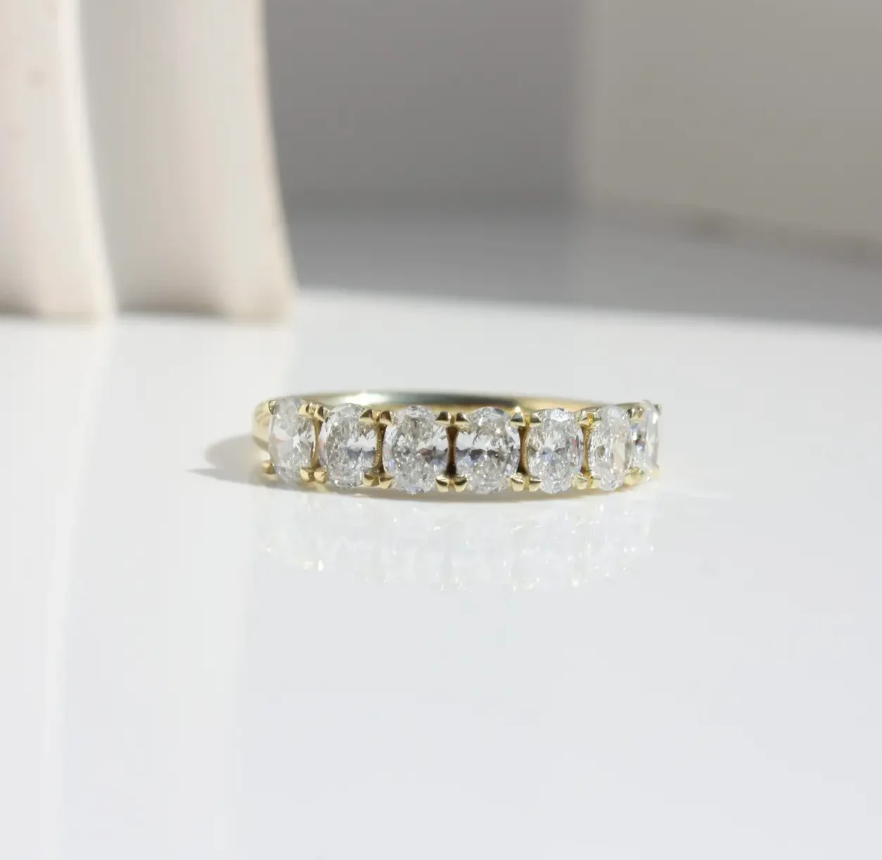 Ovaté Ring featuring a single row of oval-cut natural or lab-grown diamonds set in recycled yellow gold. Can be worn alone or as a elegant wedding ring.