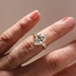 A gold ring featuring a marquise-cut diamond at the center, flanked by two smaller pear-shaped diamonds on either side, displayed against a clean white background.