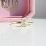 Yellow gold engagement ring with cushion cut diamond solitaire on minimalist band