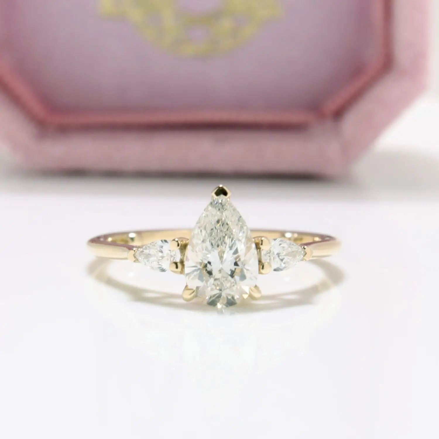 Diamond trilogy engagement ring with three brilliant-cut diamonds in a recycled yellow claw setting.