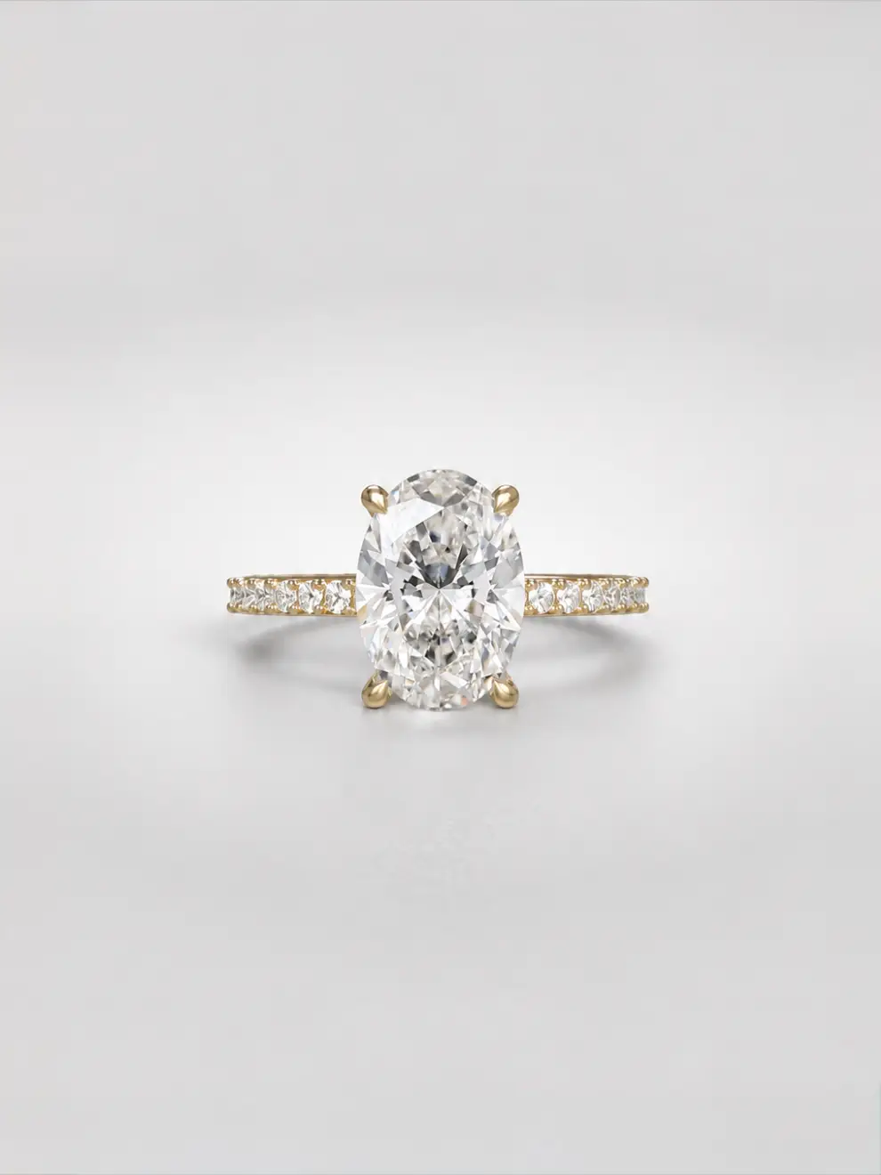 Oval diamond ring with a hidden halo and a sparkling pavé melee diamond band on a gold cathedral setting.