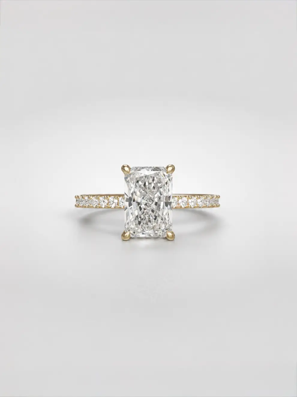 Radiant-cut diamond ring with a hidden halo and a sparkling pavé melee diamond band on a gold cathedral setting.