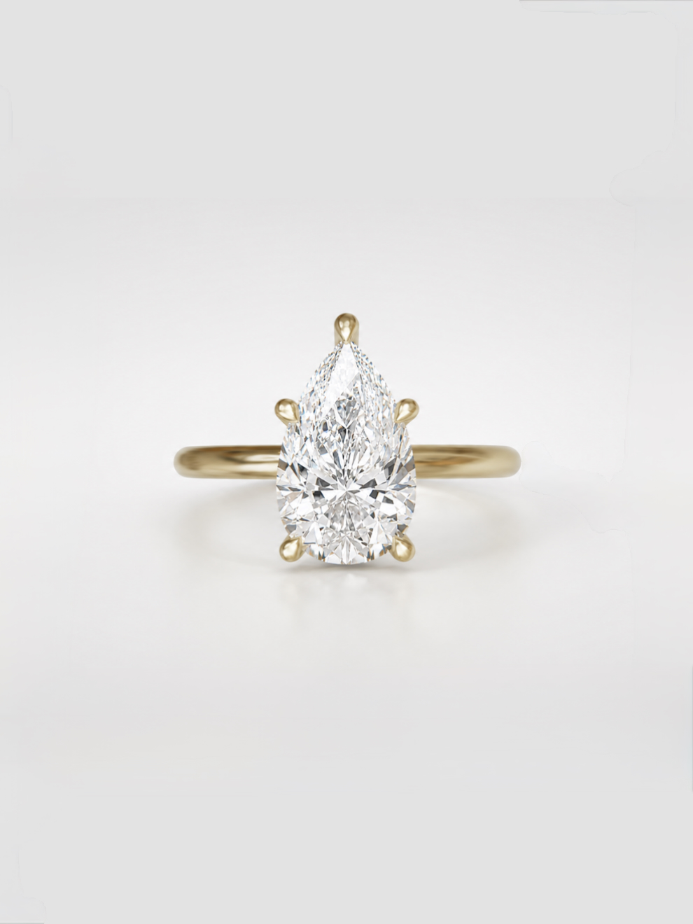 Pear-cut lab-grown diamond solitaire ring with five sleek claw prongs on a gold band.