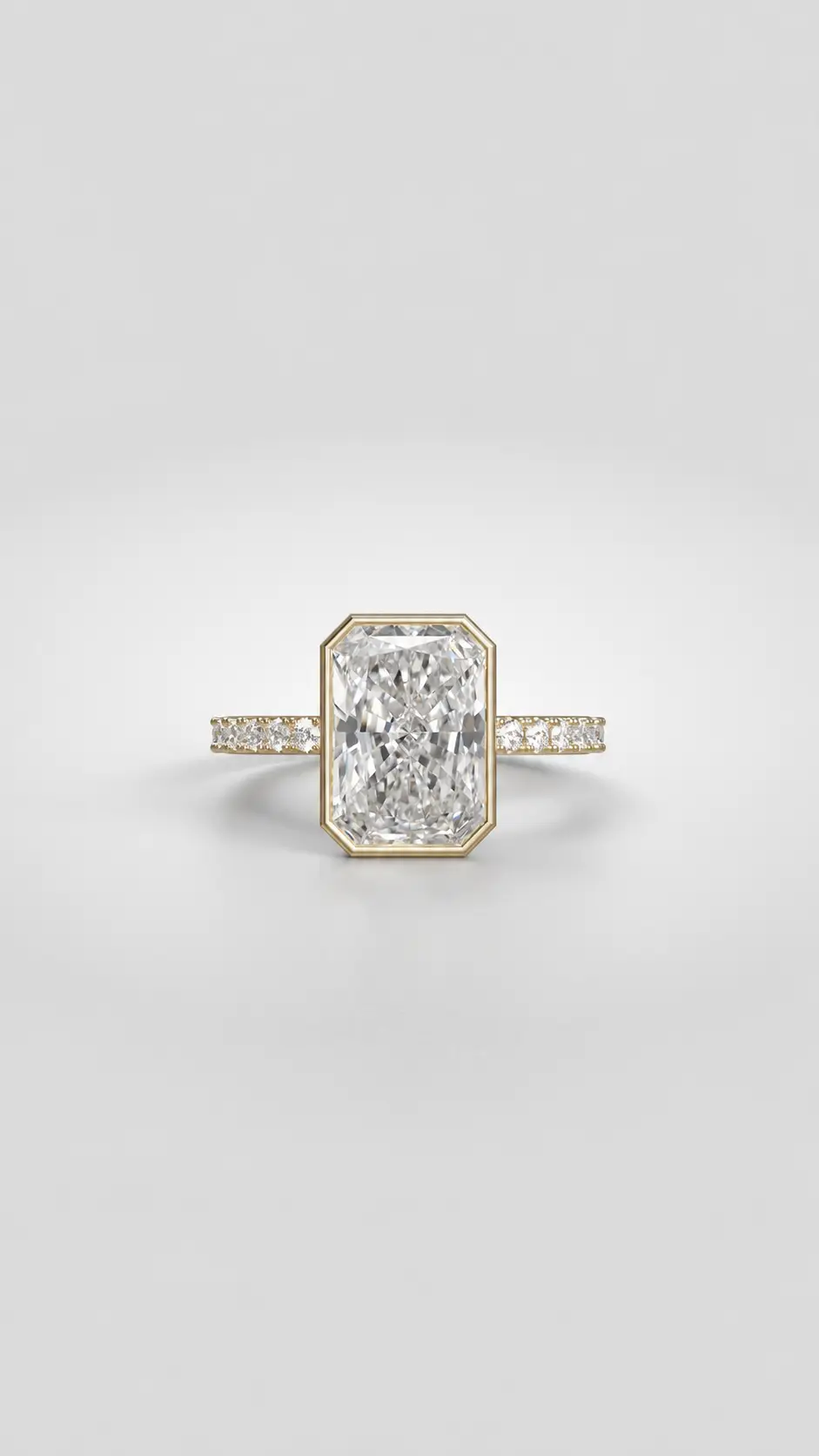 Radiant-cut diamond bezel ring with a sparkling pavé melee diamond band in gold.