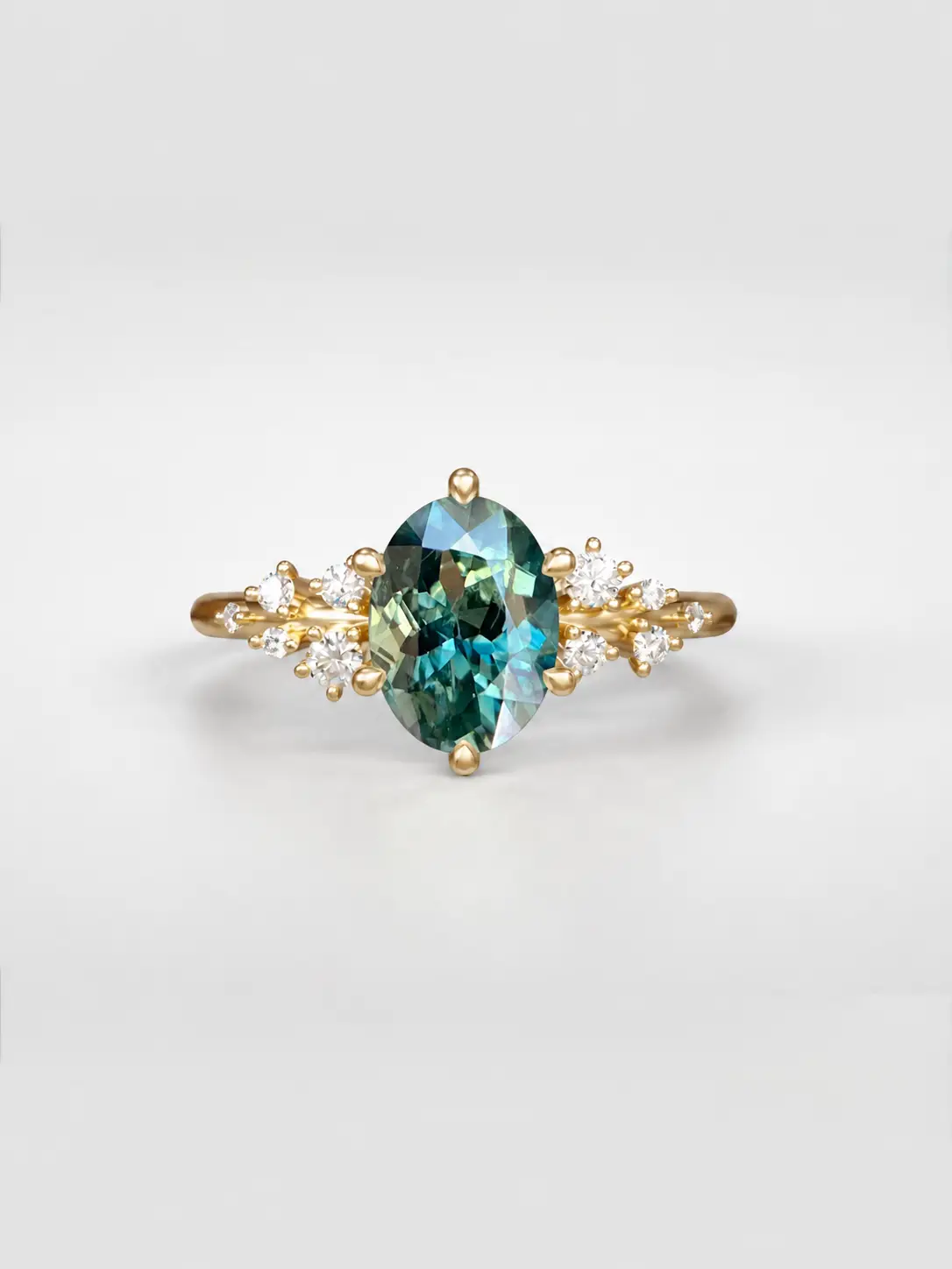 Gold cosmos cluster ring featuring a oval cut sapphirecenter stone and offset accent diamonds.