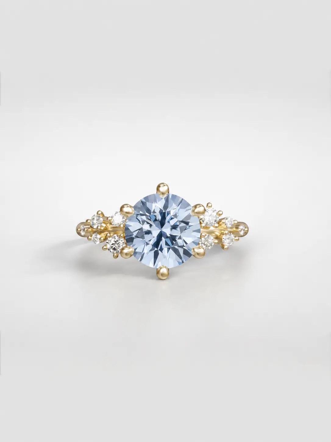 Gold cosmos cluster ring featuring a round sapphire center stone and offset accent diamonds.