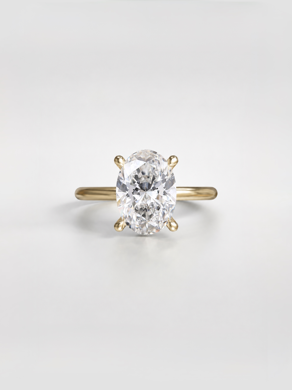 Oval diamond solitaire ring with four sleek claw prongs on a gold band