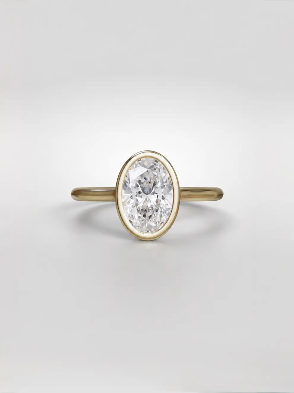Bezel-set oval lab-grown diamond ring in a sleek gold tube mounting on an elevated cathedral setting.