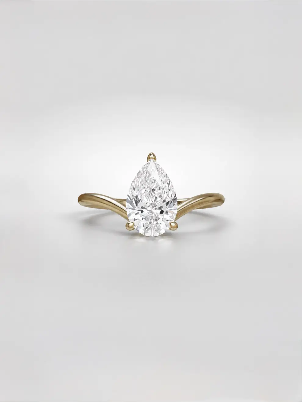 Pear diamond engagement ring with a hidden halo and a wishbone gold band.