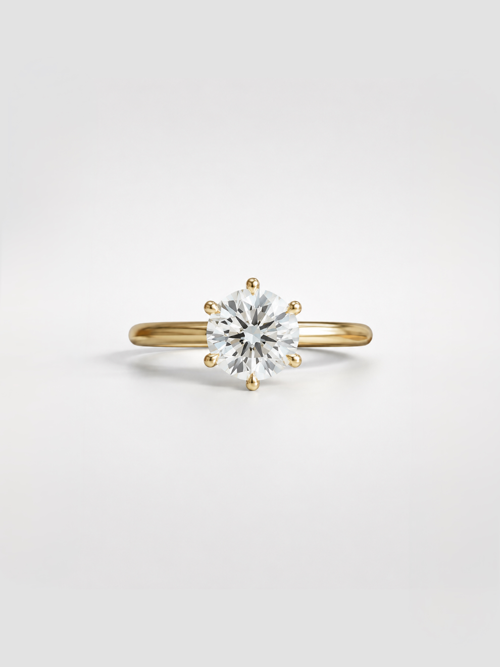 Round brilliant-cut lab-grown diamond solitaire ring with six sleek claw prongs on a gold band.