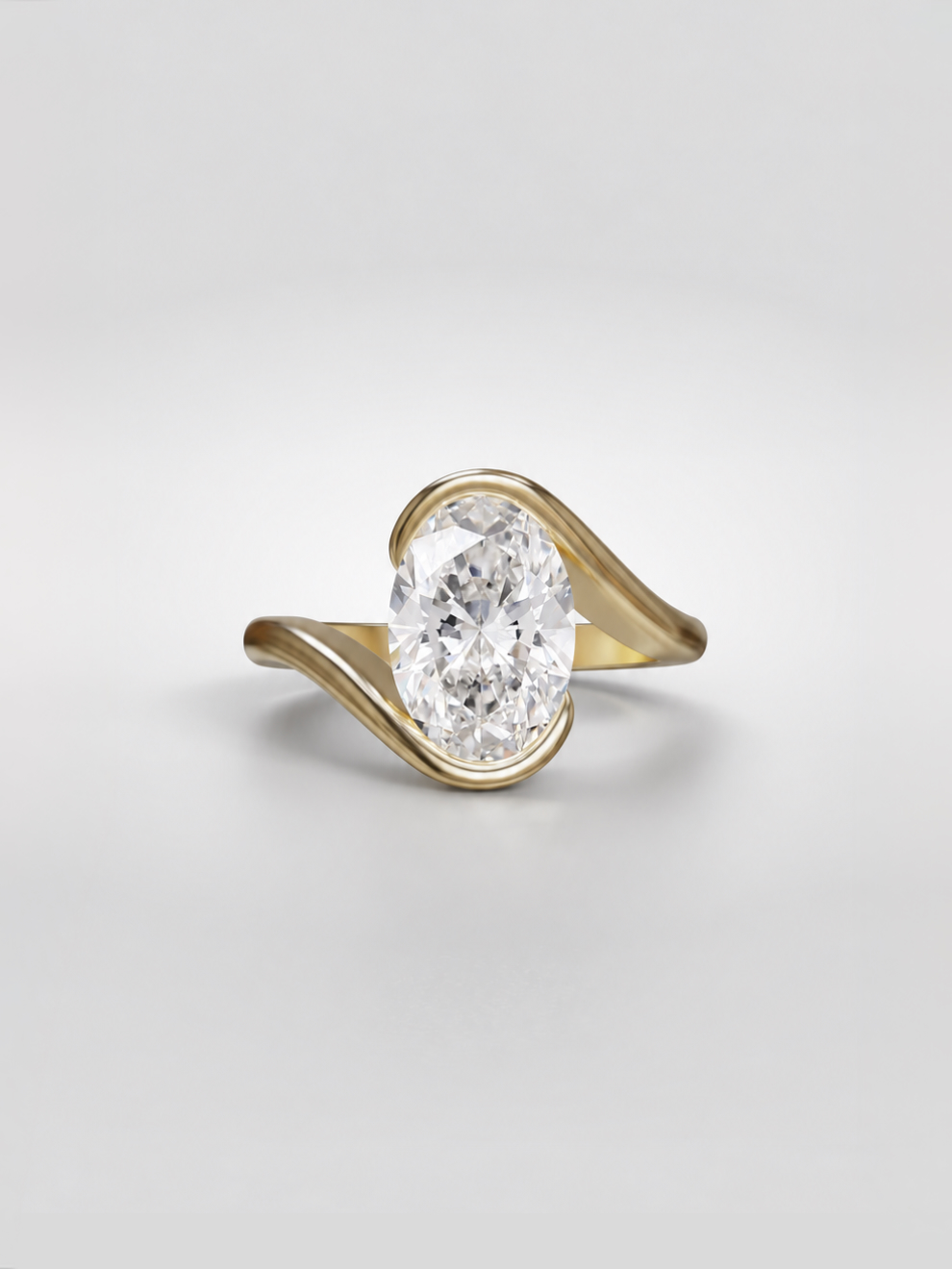 Oval lab-grown diamond bypass ring featuring a secure half bezel setting within a sculptural gold band.