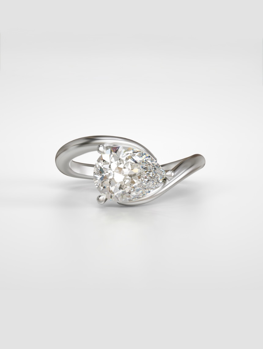 East-west pear diamond solitaire ring nestled in a gold bypass band.