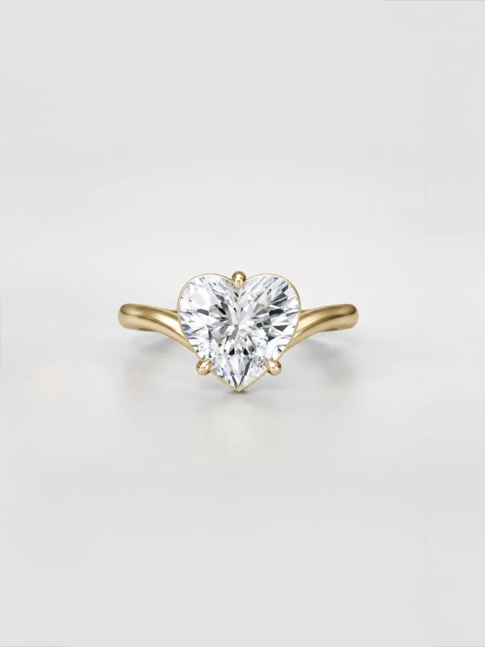 Heart brilliant-cut diamond solitaire ring with cascading gold band.