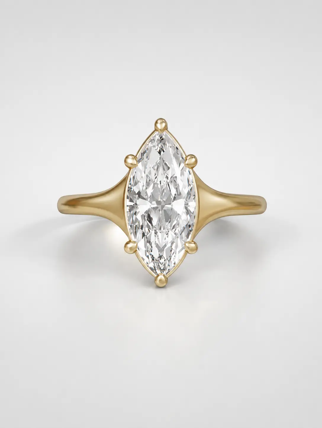 Marquise cut diamond solitaire engagement ring on a tapered yellow gold band with a collet setting.